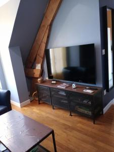 a living room with a large flat screen tv at L'entre-potes in Sully-sur-Loire