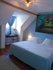 a bedroom with a large white bed and a desk at L'entre-potes in Sully-sur-Loire