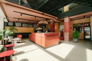 a restaurant with a counter and tables and chairs at The Social Hub Eindhoven in Eindhoven