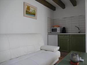 cocina pequeña con sofá blanco y microondas en Loft Yedra, en Almagro