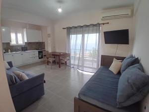 a living room with a blue couch and a kitchen at Panorama Palace 1 in Palasë +15 photos