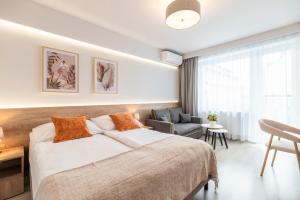 a bedroom with a large bed and a chair at Villa Baltica II in Rewa