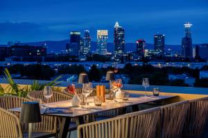 a table with wine glasses and a view of the city at The Blasky in Frankfurt