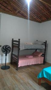 a bedroom with a bunk bed and a chair at Bella Serra in Iporanga
