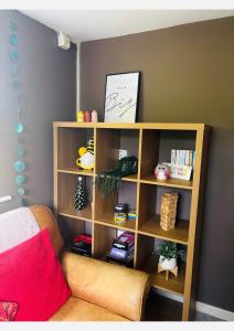 a book shelf in a room with a couch at Dolmans Retreat in Lytchett Matravers +14 photos
