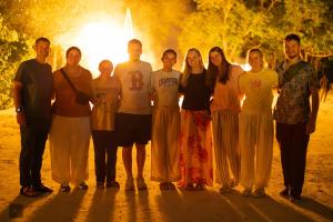 Eine Gruppe von Menschen steht vor einem Feuer in der Unterkunft Dhonveli Hotel in Shaviyani Atoll