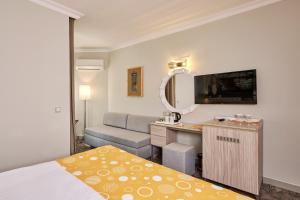 a hotel room with a bed and a desk and a mirror at Fun Sun Smart Akman Beach in Kemer