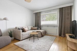 a living room with a couch and a table at Central Lapland Apartment By Lapland Host in Rovaniemi