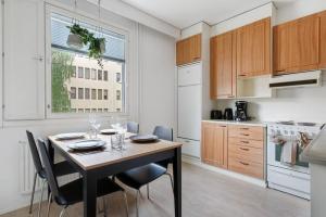 a kitchen with a table and chairs in a kitchen at Central Lapland Apartment By Lapland Host in Rovaniemi