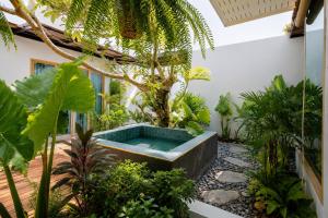 a garden with a hot tub in the middle of a building at Ma's Sea Beach House in Klong Muang Beach +109 photos