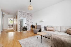 a living room with a couch and a table at Central Lapland Apartment By Lapland Host in Rovaniemi