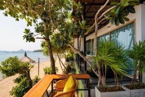 a table and chairs on the beach near a resort at Ma's Sea Beach House in Klong Muang Beach