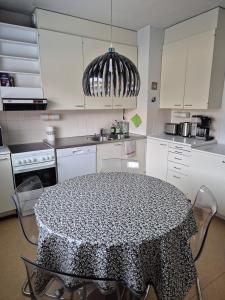 a kitchen with a black and white table with chairs at Apartment with private sauna in Loimaa +10 photos