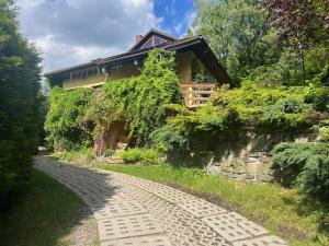 a stone path leading to a house with a building at Dom na wzgórzu - Brenna in Brenna
