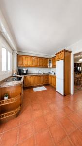 a kitchen with wooden cabinets and a white refrigerator at Casa Eloah in Antequera