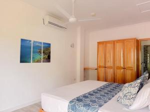a bedroom with a bed and a painting on the wall at Cove Holiday Apartments in Bel Ombre +46 photos