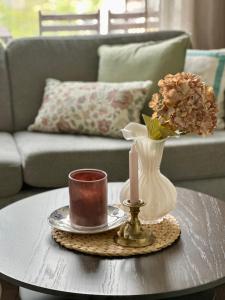 a coffee table with a candle and a vase with flowers at Mountain and Sea View Svolvær in Svolvær