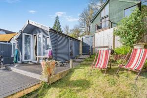 a deck with two chairs and a tiny house at 1 Bed in Totnes oc-bc1000 in Totnes