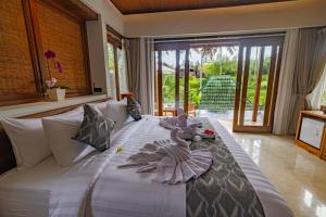 a bedroom with a bed with stuffed animals on it at The Dura Ubud in Ubud +76 photos