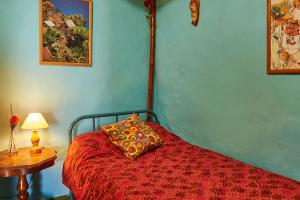 a bedroom with a bed with a red comforter and a table at Casitas Manuel in El Paso