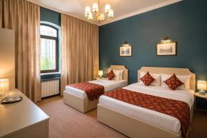 a hotel room with two beds and a desk at The Lantern Central Hotel in Baku
