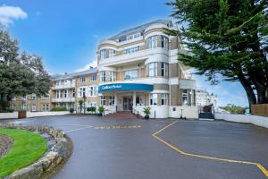 a building with a parking lot in front of it at Bournemouth Carlton Hotel By Sunday in Bournemouth