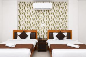 a bedroom with two beds and a wall with a wallpaper at Hotel Golden Ring in Lucknow