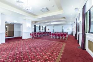 a room with red chairs and a screen in it at Bournemouth Carlton Hotel By Sunday in Bournemouth