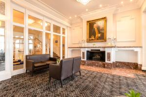 a living room with a fireplace and two chairs at Bournemouth Carlton Hotel By Sunday in Bournemouth