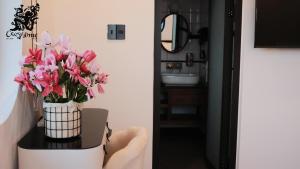 a vase of pink flowers on a table in a bathroom at CozyhomeDaLat in Khu Chi Lăng +69 photos