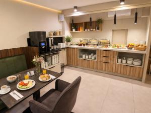 a kitchen with a table and chairs with food on it at Apart Home Tel AHT in Krapkowice