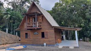a small wooden house with a porch and a deck at Chalé do Beleza - Serra do Corvo in Braço do Norte
