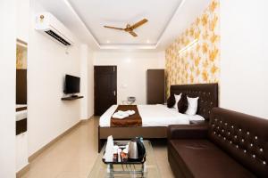 a hotel room with a bed and a couch at Hotel Golden Ring in Lucknow