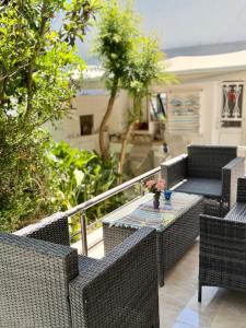 a patio with wicker chairs and a table on a balcony at Cleopatra's House Apartments in Archangelos