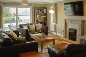 a living room with leather furniture and a fireplace at Orchard House Wadebridge Self Catering in Wadebridge