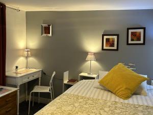 a bedroom with a bed and a desk and two lamps at Beulah Serviced bedrooms in Aberdeen