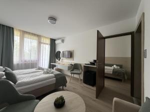 a hotel room with two beds and a mirror at Apartman Hotel in Bük