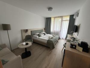a bedroom with a bed and a couch and a table at Apartman Hotel in Bük +78 photos