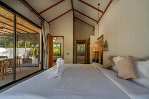 a large white bed in a room with a table at K Villas Phangan 01 in Thong Sala +49 photos