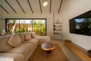 a living room with a couch and a flat screen tv at K Villas Phangan 01 in Thong Sala
