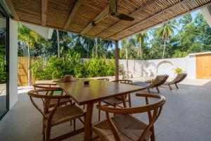 a dining room with a wooden table and chairs at K Villas Phangan 01 in Thong Sala