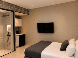 a bedroom with a bed and a television on the wall at Dizengoff Square Garden - by BAR COLLECTION in Tel Aviv