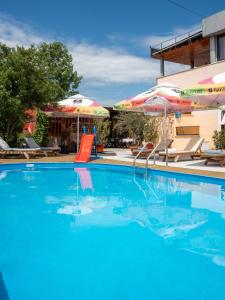 a swimming pool with a slide and umbrellas at Hotel Boutique Casa Venusian in Venus