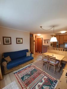 a living room with a blue couch and a table at Appartamento Marmolada in Pieve di Livinallongo