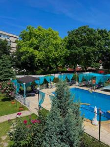 a large swimming pool with blue tarps around it at Apatcomplex Diva &restaurant&bar in Saints Constantine and Helena