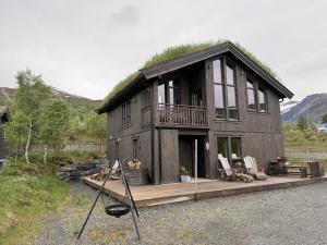 a house with a grass roof on a wooden deck at Harevadet 217 in Volda