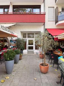 a patio with potted plants in front of a building at Uferglanz - Balcony, view, sparkling wine, snacks in Koblenz