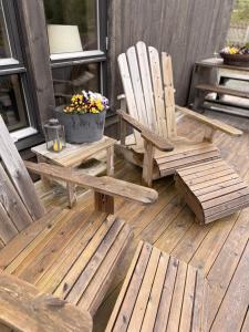 two wooden chairs sitting on a deck with a pot of flowers at Harevadet 217 in Volda +27 photos