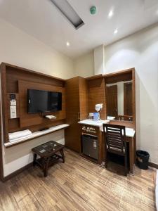 a room with a television and a table and a chair at Aura Grand Amritsar in Amritsar