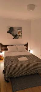 a bedroom with a bed with a picture on the wall at Plantier Guesthouse in Figueira de Castelo Rodrigo